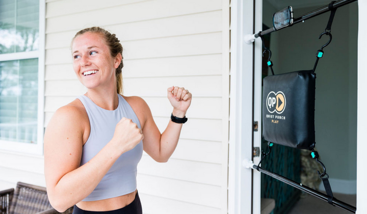 Woman working out with Quiet Punch doorway punching bag during a fitness session