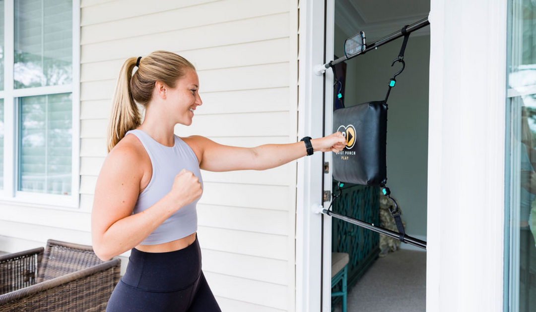 Woman using the best doorway punching bag system from Quiet Punch for a cardio workout