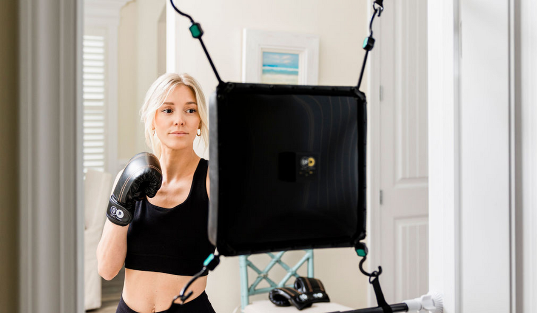 Focused female boxer training on the Quiet Punch system, the best punching bag for doorways